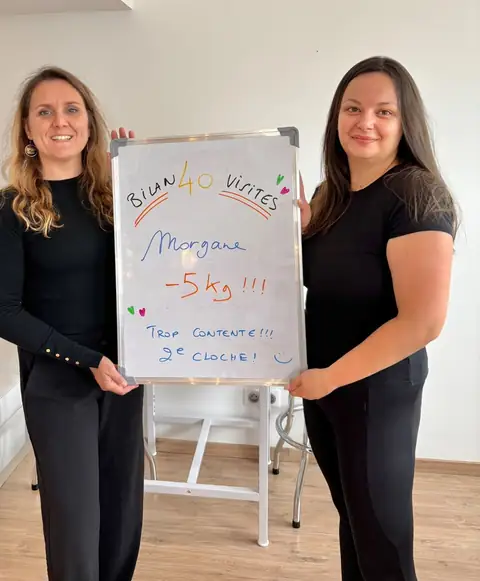 Une membre fait voir son bilan noté à l’ardoise blanche, en pleine salle
